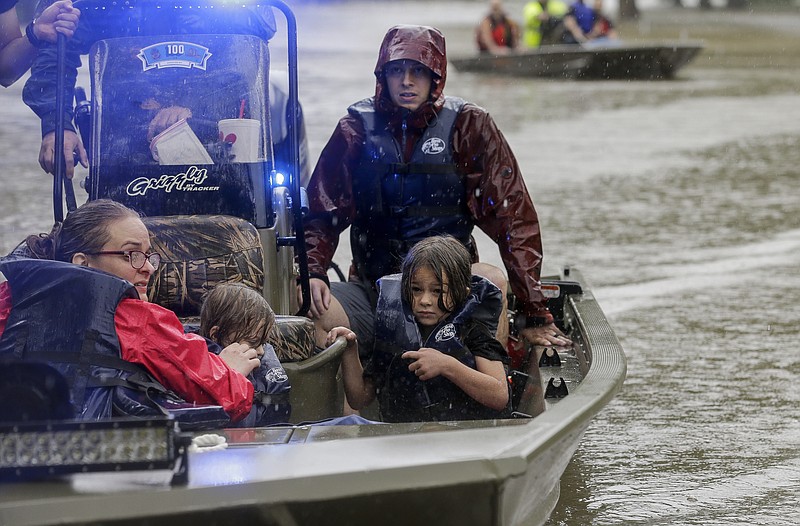 First responders with the Harris County Sheriff's Office, Texas Game Warden, and Huffman Fire Department rescued people from flooded homes in the Lochshire neighborhood Friday, Sept. 20, 2019, in Huffman, Texas. Emergency workers used boats Friday to rescue about 60 residents of a Houston-area community still trapped in their homes by floodwaters following one of the wettest tropical cyclones in U.S. history. (Godofredo A. Vásquez/Houston Chronicle via AP)