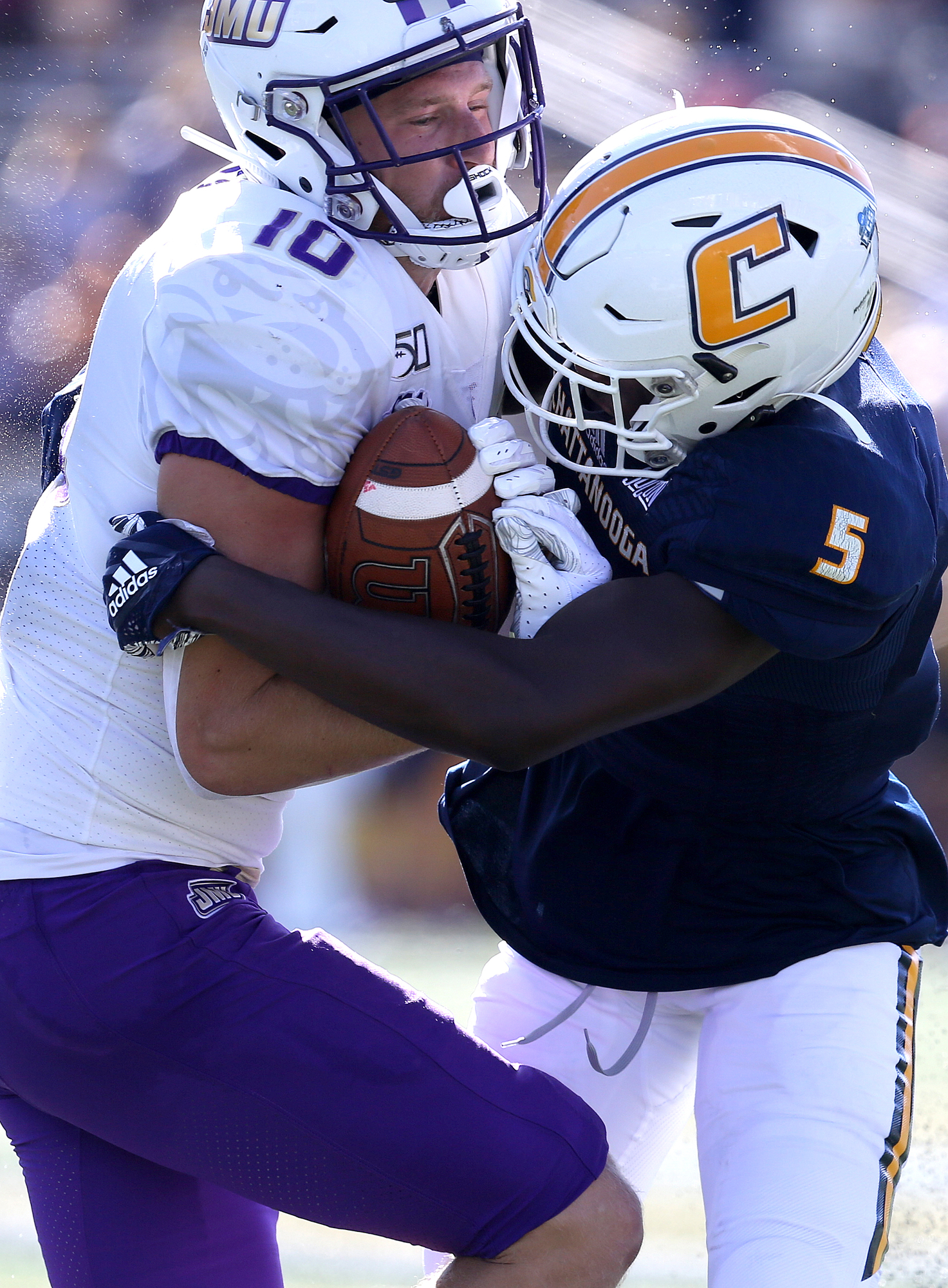 Staff photo by Erin O. Smith / James Madison University wide receiver Riley Stapleton (10) pushes for more yardage as UTC"s CaMiron Smith (5) pulls him down during the UTC vs. James Madison University NCAA football game Saturday, August 21, 2019 at Finley Stadium in Chattanooga, Tennessee. JMU was up 20-14 at the half.