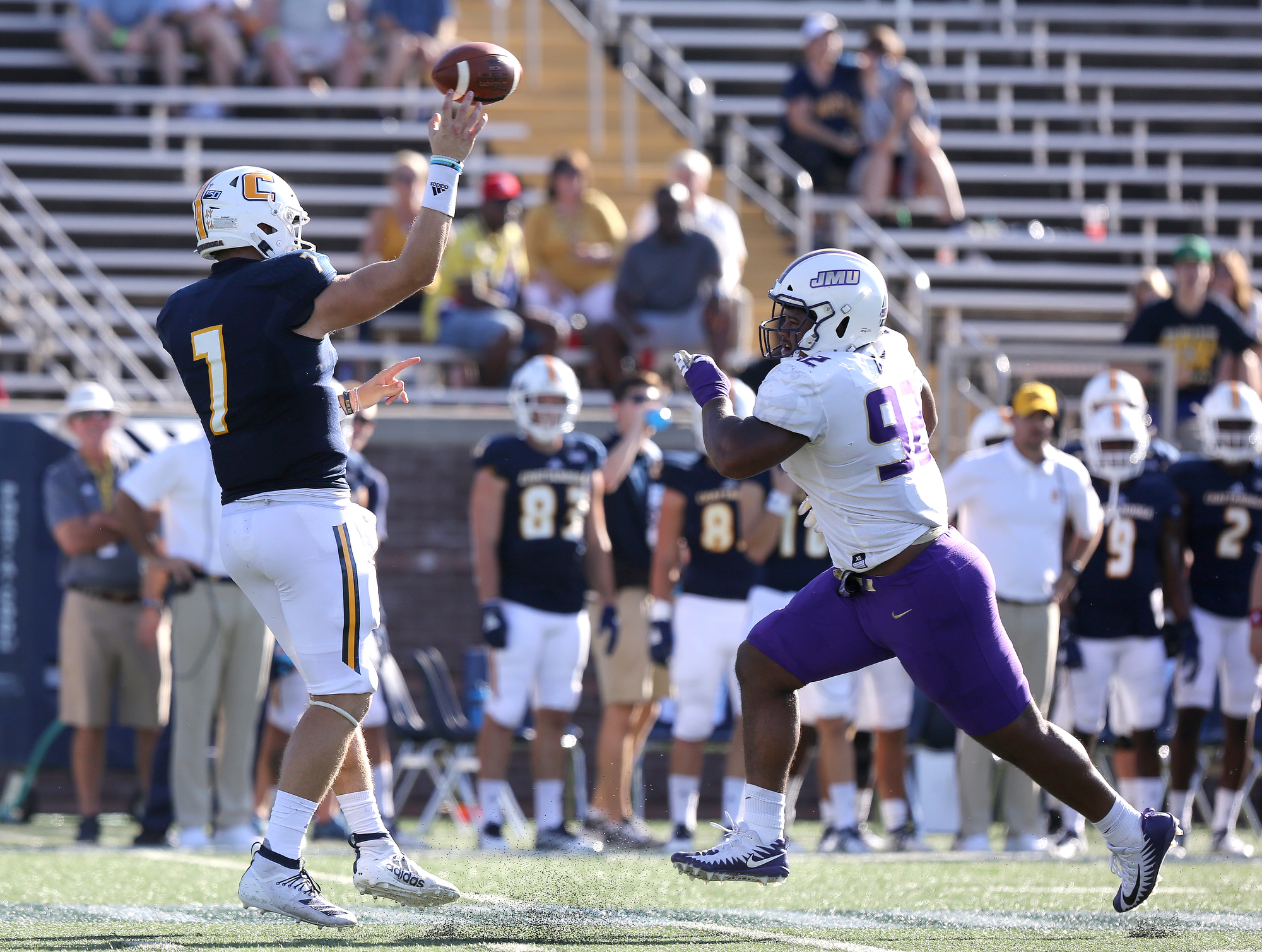 Staff photo by Erin O. Smith / UTC quarterback Nick Tiano (7) gets a pass off just in time as James Madison University's Mike Greene (92) nears him during the UTC vs. James Madison University NCAA football game Saturday, August 21, 2019 at Finley Stadium in Chattanooga, Tennessee. JMU was up 20-14 at the half.