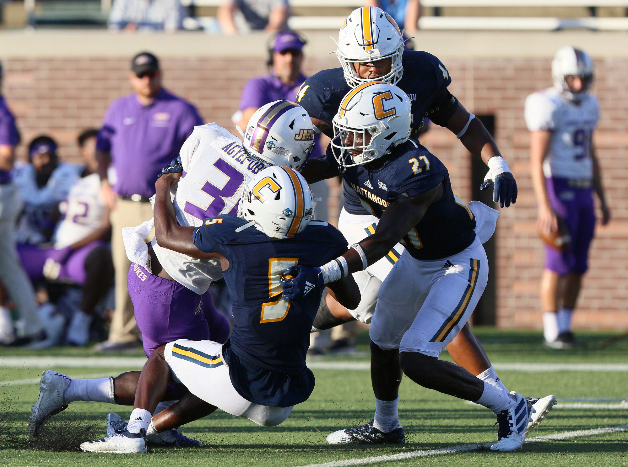 Staff photo by Erin O. Smith / James Madison University's Percy Agyei-Obese (31) is tackled by UTC's CaMiron Smith (5) and Jarrell Lawson (27) during the UTC vs. James Madison University NCAA football game Saturday, August 21, 2019 at Finley Stadium in Chattanooga, Tennessee. JMU beat UTC with a score of 37-14.