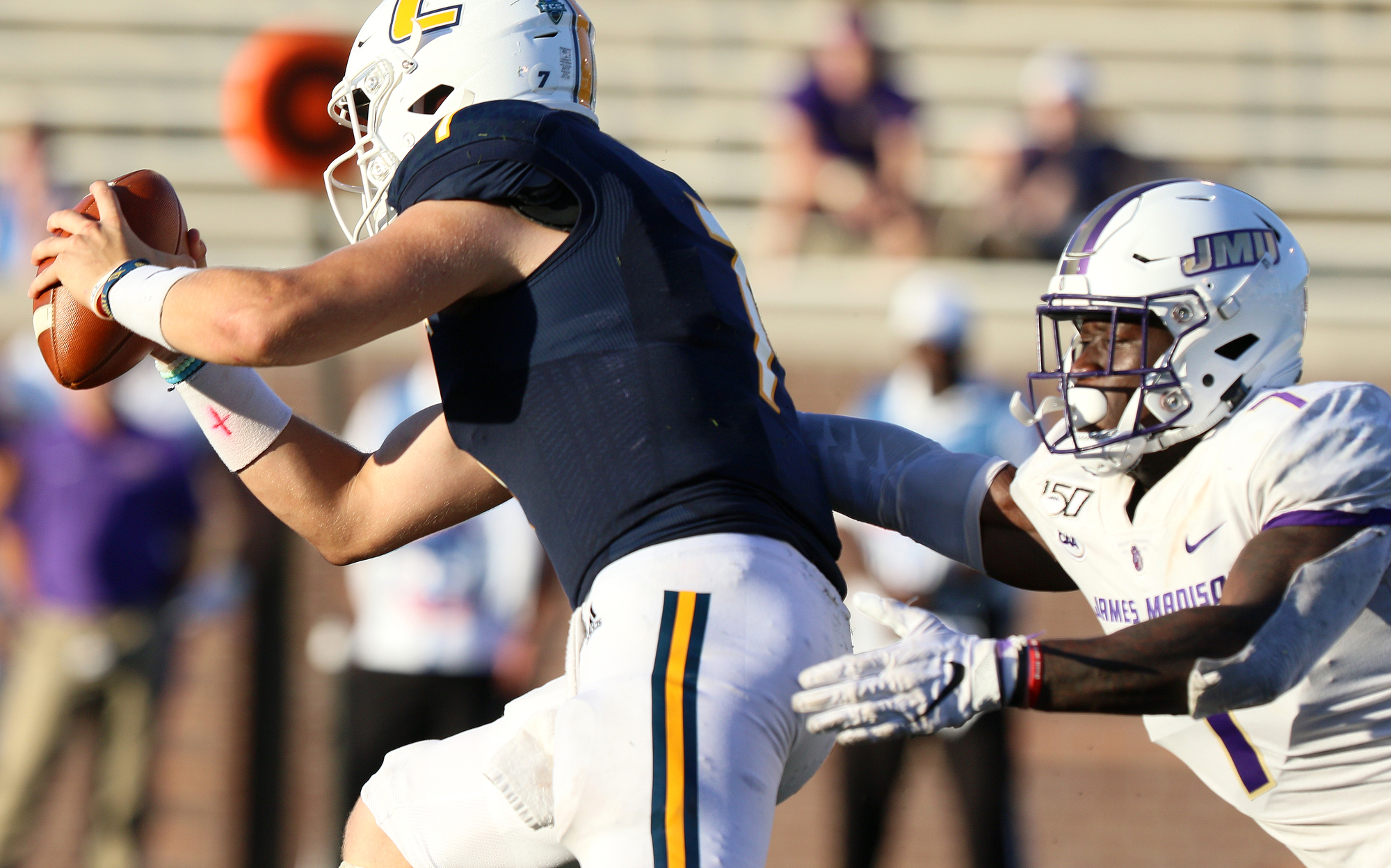 Staff photo by Erin O. Smith / UTC quarterback Nick Tiano (7) runs the ball as James Madison University's John Daka (7) slips up behind him during the UTC vs. James Madison University NCAA football game Saturday, August 21, 2019 at Finley Stadium in Chattanooga, Tennessee. JMU beat UTC with a score of 37-14.