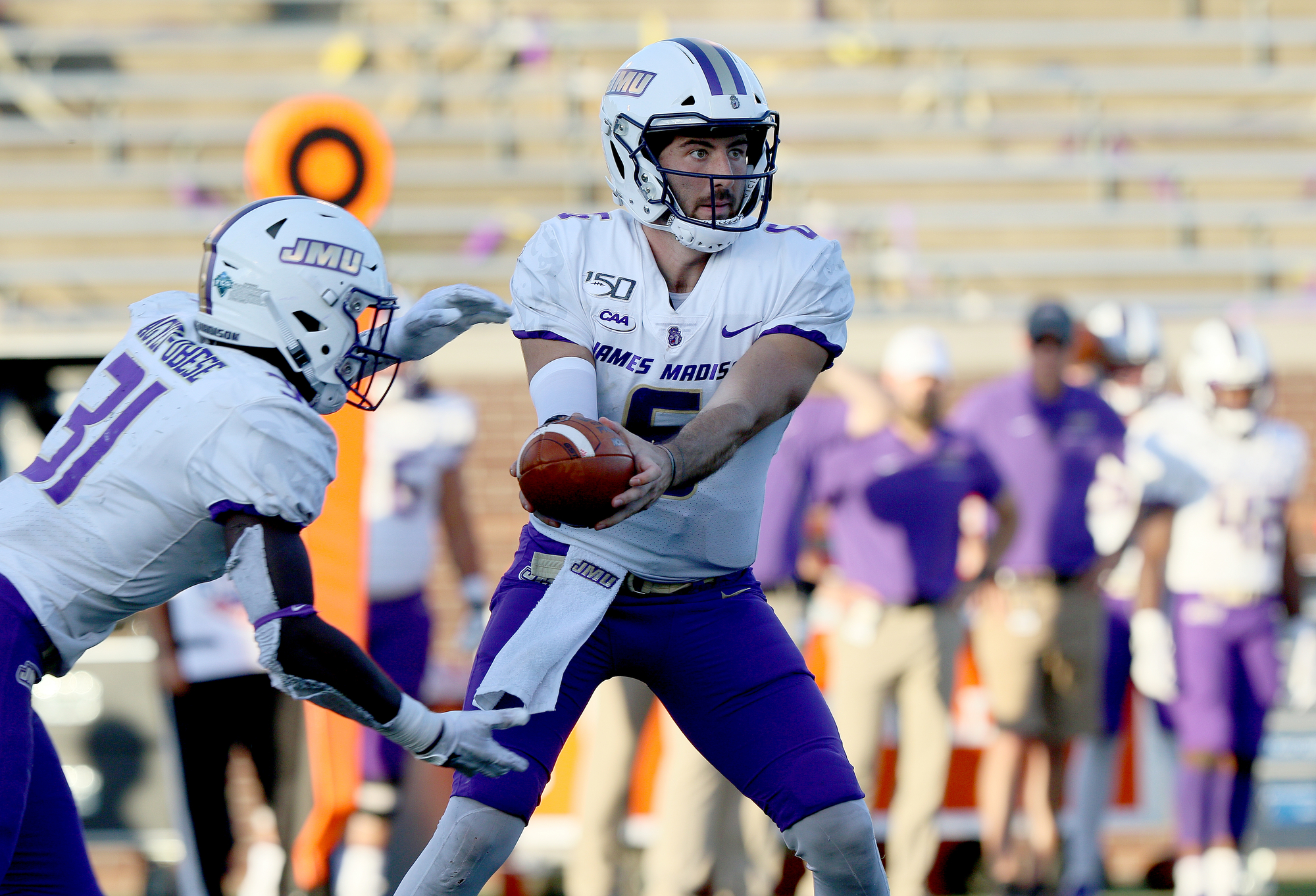 Staff photo by Erin O. Smith / James Madison University quarterback Ben DiNucci (6) hands the ball off to Percy Agyei-Obese (31) during the UTC vs. James Madison University NCAA football game Saturday, August 21, 2019 at Finley Stadium in Chattanooga, Tennessee. JMU beat UTC with a score of 37-14.