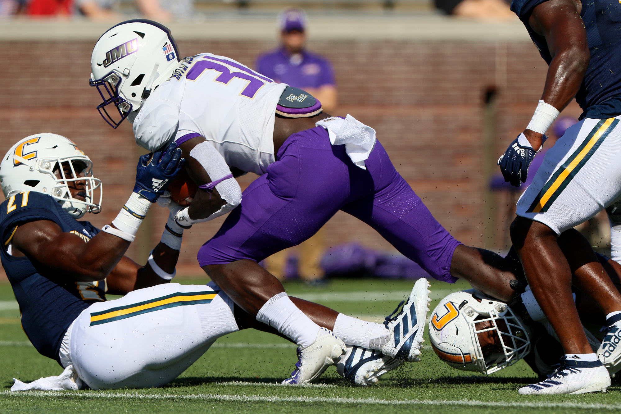 Staff photo by Erin O. Smith / UTC's Jarrell Lawson (27) pulls down James Madison University's Percy Agyei-Obese (31) during the UTC vs. James Madison University NCAA football game Saturday, August 21, 2019 at Finley Stadium in Chattanooga, Tennessee. JMU beat UTC with a score of 37-14.
