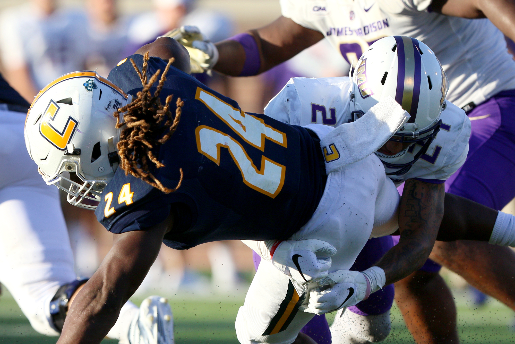Staff photo by Erin O. Smith / UTC's Elijah Ibitokum-Hanks (24) is tripped up during the UTC vs. James Madison University NCAA football game Saturday, August 21, 2019 at Finley Stadium in Chattanooga, Tennessee. JMU beat UTC with a score of 37-14.