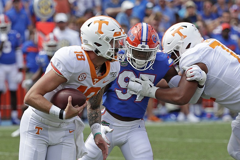 Associated Press photo by John Raoux / Tennessee freshman quarterback Brian Maurer, left, scrambles for yardage as he is pressured by Florida linebacker Khris Bogle during the second half of Saturday's game in Gainesville, Fla.