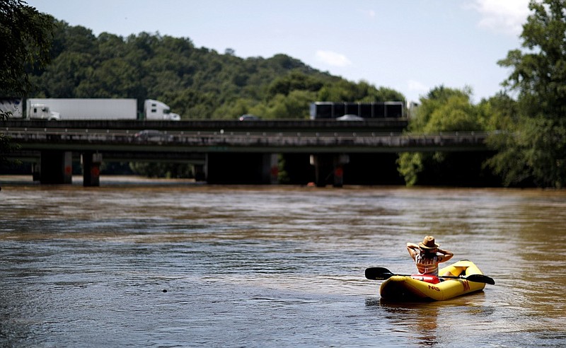 FILE - This June 27, 2018 file photo shows a kayaker floating down the Chattahoochee River as traffic spans Interstate 285 in Atlanta. The toe-tapping river song that rhymes Chattahoochee with "hoochie coochie" was one of the biggest hits of Alan Jackson's career, earning him two Country Music Association Awards and two Grammy nominations. (AP Photo/David Goldman, File)


