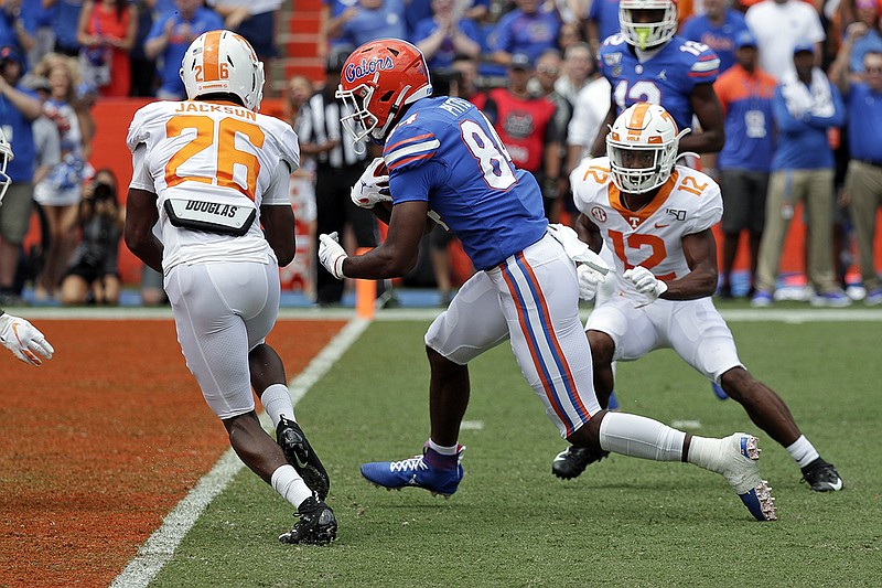 Associated Press photo by John Raoux / Florida tight end Kyle Pitts, center, runs past Tennessee defensive backs Theo Jackson, left, and Shawn Shamburger on a 19-yard touchdown catch during the first half of Saturday's game in Gainesville, Fla.