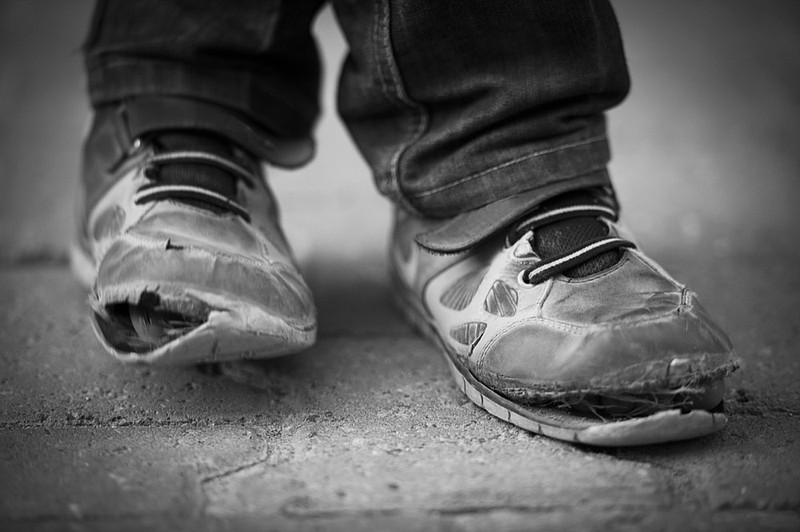 Village boy in Turkey wearing pair of old shoes. child poverty tile / Getty Images
