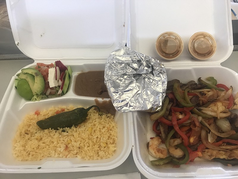 The combo fajita platter to go comes in two Styrofoam containers complete with beans, rice, a roasted jalapeno and a small mixture of avocado, pico, lettuce and sliced radishes.