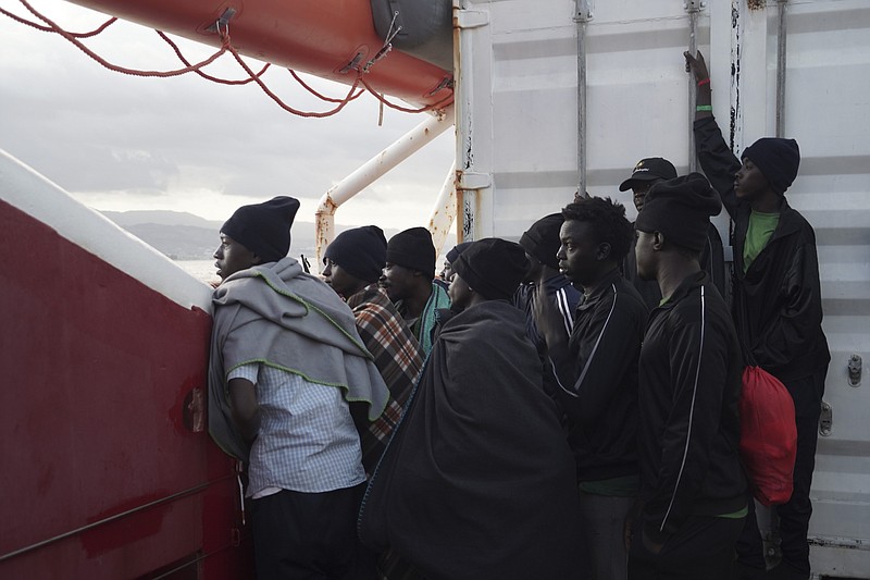 Men wait to disembark from the Ocean Viking ship as it reaches the port of Messina, Italy, Tuesday, Sept. 24, 2019.  The humanitarian ship has docked in Italy to disembark 182 men, women and children rescued in the Mediterranean Sea after fleeing Libya. (AP Photo/Renata Brito)