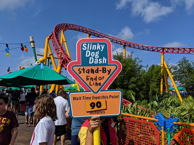 Photo by Christopher Elliott / A Disney World cast member holds a sign warning of a 90-minute wait for a popular ride.