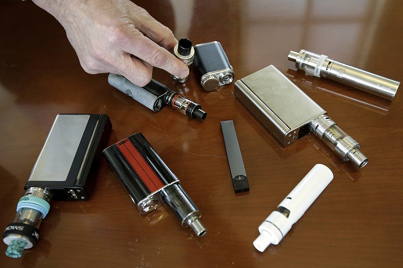 FILE - In this Tuesday, April 10, 2018 photo, a high school principal displays vaping devices that were confiscated from students at the school in Massachusetts. On Thursday, Sept. 26, 2019, the Centers for Disease Control and Prevention said 805 confirmed and probable cases have been reported to have a vaping-related breathing illness, and the death toll has risen to 12. (AP Photo/Steven Senne)