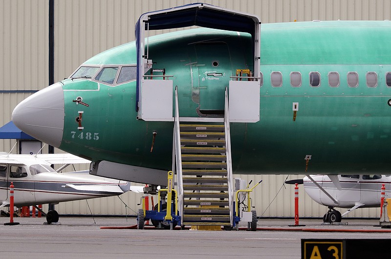 FILE - In this April 8, 2019, file photo a Boeing 737 MAX 7 jet is parked near single engine planes at the airport adjacent to a Boeing Co. production facility in Renton, Wash. Federal safety officials say Boeing should consider how cockpit confusion can slow the response of pilots who are dealing with the kind of problem that likely caused two airliners to crash in the past year. (AP Photo/Elaine Thompson, File)