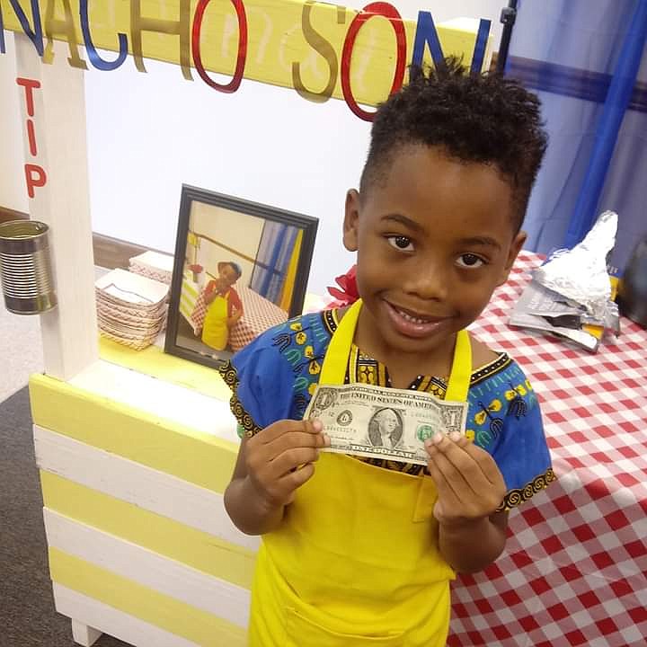 Contributed photo by Shea Jennings / Zi'on Jones holds up a dollar earned through his business, Nacho Son.