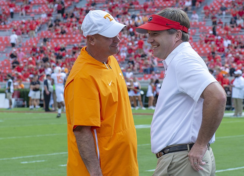 Georgia photo by Al Eckford / Tennessee football coach Jeremy Pruitt shares a laugh with Georgia counterpart Kirby Smart before last season's game in Athens.