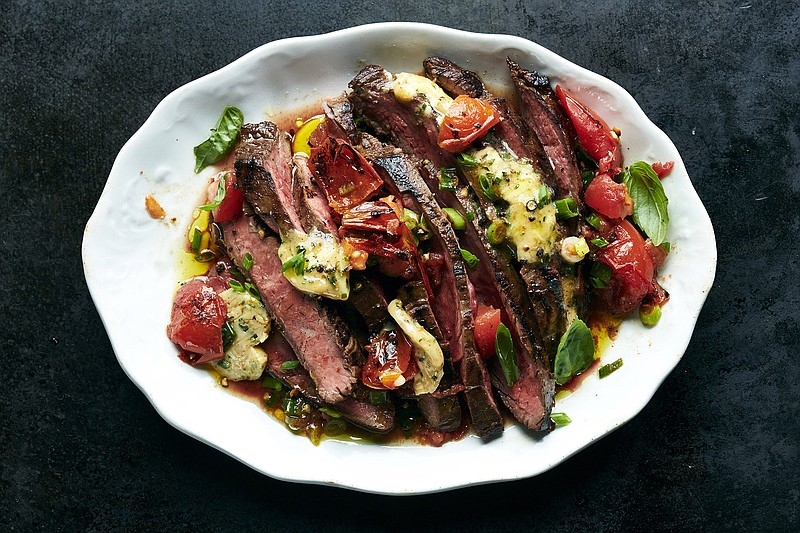 Grilled flank steak topped with Worcestershire butter and charred ripe tomatoes in New York, June 6, 2019. What flank steak lacks in softness, it makes up for with a deeply mineral brawniness that can stand up to the spiciest, tangiest, most pungent marinades. Food Stylist: Simon Andrews. (David Malosh/The New York Times)