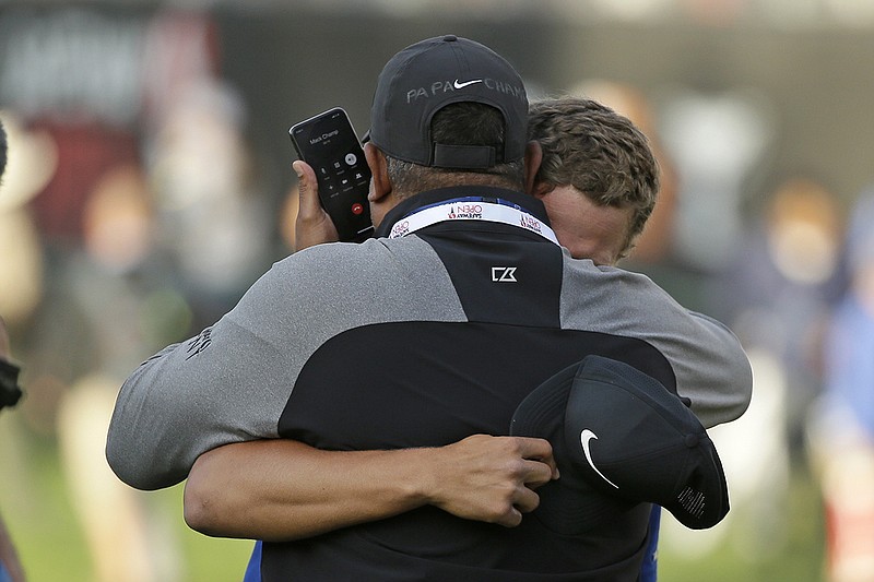 AP photo by Eric Risberg / Cameron Champ, right, embraces his father, Jeff, on the 18th green of the Silverado Resort North Course after winning the Safeway Open on Sept. 29, 2019, in Napa, Calif. They were speaking by phone to Champ's grandfather, Mack, who has cancer and is in hospice care in Sacramento.