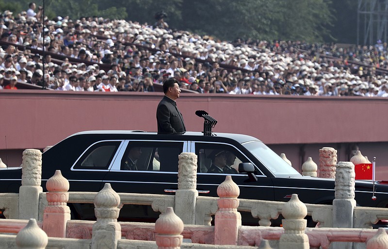 Chinese leader Xi Jinping rides in an open-top limousine during a parade to mark the 70th anniversary of the founding of Communist China in Beijing, Tuesday, Oct. 1, 2019. (AP Photo/Ng Han Guan)