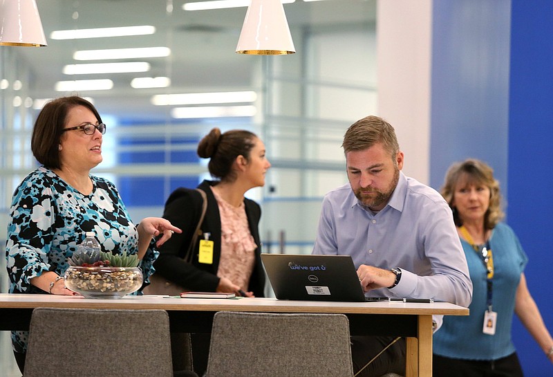 Staff photo by Erin O. Smith / April Gordon, executive assistant to the Unum CEO, and Tim Vita, chief of staff at Unum, talk in a common area in the newly renovated facility at Unum Tuesday Oct. 1, 2019 in Chattanooga, Tennessee. Unum's renovated space has a local coffee shop, flexible desk seating, a variety of offices, lockers and more for employees. 