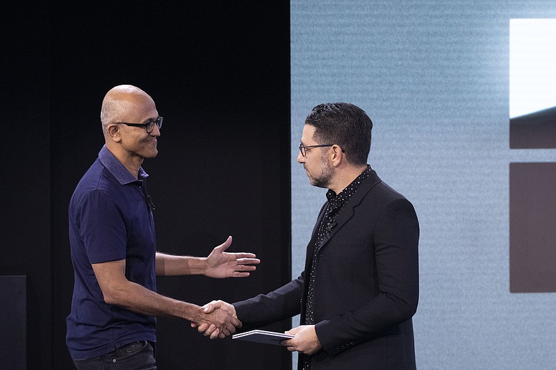 CORRECTS SPELLING OF FIRST NAME TO SATYA INSTEAD OF SAYS - Microsoft CEO Satya Nadella, left, shakes hands with Chief Product Officer Panos Panay, who is holding a Surface Duo at an event Wednesday, Oct. 2, 2019, in New York. (AP Photo/Mark Lennihan)