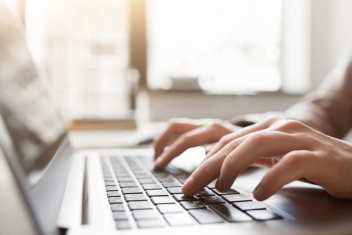 Typing on laptop closeup, chatting in Facebook, meeting website. Blogger, journalist writing new article. / Getty Images/iStockphoto/golubovy