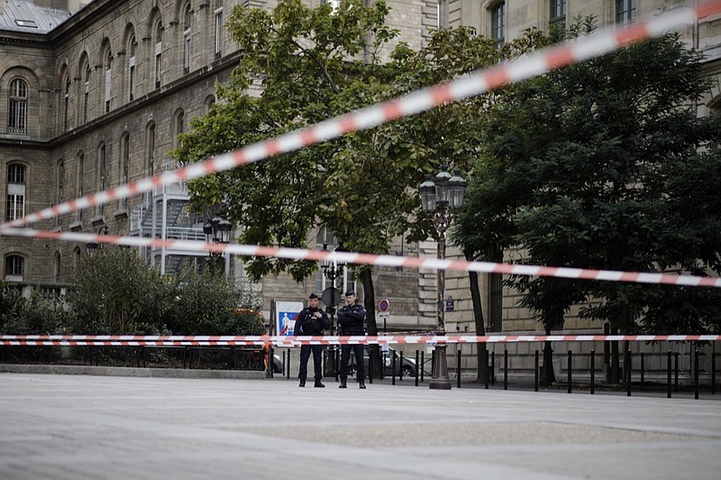Police officers stand guard outside the Paris police headquarters, Thursday, Oct.3, 2019 in Paris. An employee armed with a knife attacked officers inside Paris police headquarters Thursday, killing at least four before he was fatally shot, a French police union official said. (AP Photo/Kamil Zihnioglu)