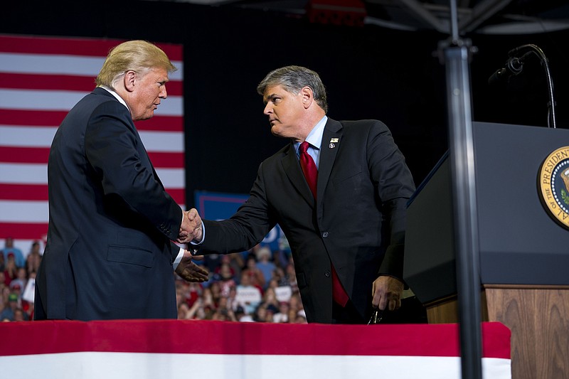 File photo by Doug Mills of The New York Times / President Donald Trump greets Fox News' Sean Hannity onstage during a campaign rally at the Show Me Center in Cape Girardeau, Missouri, in November 2018.