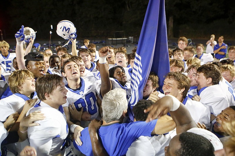 Staff photo by C.B. Schmelter / McCallie celebrates with head coach Ralph Potter, bottom, after defeating Baylor 35-28 at Heywood Stadium on the campus of Baylor School on Friday, Oct. 4, 2019 in Chattanooga, Tenn.