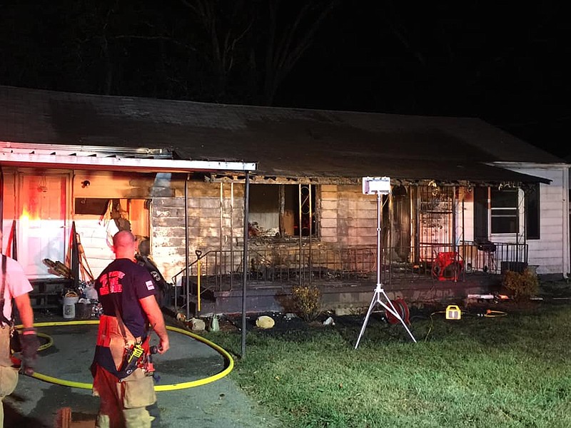 Firefighters with the East Ridge Fire Department assess damage to a home on South Moore Road on Friday that sent two occupants to a local hospital.