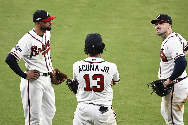 AP photo by Scott Cunningham / From left, Atlanta Braves outfielders Nick Markakis, Ronald Acuna Jr. and Matt Joyce speak in the top of the ninth inning during Game 1 of the team's NL Division Series against the St. Louis Cardinals on Thursday.