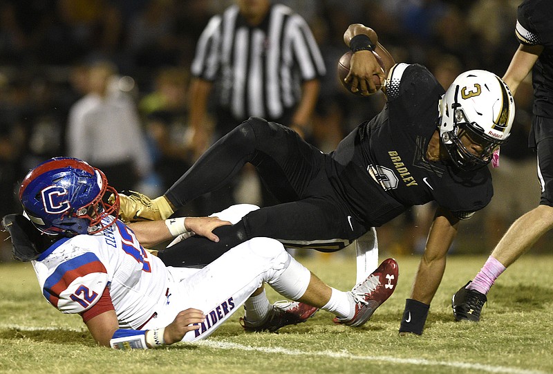 Staff Photo by Robin Rudd / Bradley Central's Javin Burke, right, tries to avoid going down as he escapes the tackle of Cleveland's Zach Turner during Friday night's game at Bradley Central.