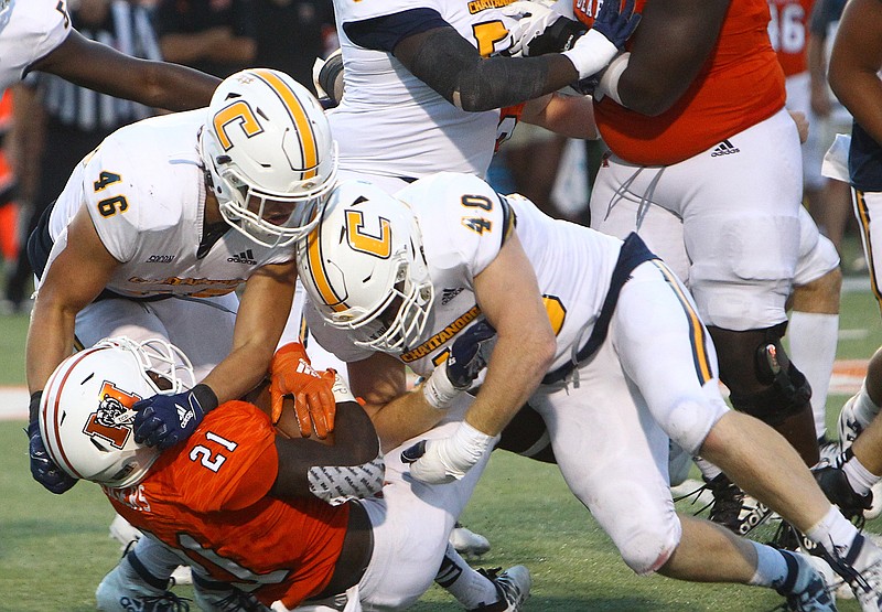 UTC photo by Dale Rutemeyer / UTC's Ty Boeck (46) and Marshall Cooper (40) tackle Mercer running back Kareem Rogers during Saturday's game in Macon, Ga.