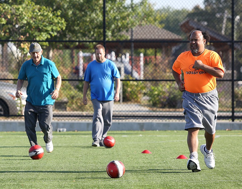 Staff photo by Erin O. Smith / Larry Bowman, John Thompson and Eugene Kemp play a modified version of sharks and minnows during an Operation Get Active Kickstart soccer session at Highland Park Commons Thursday, Oct. 3, 2019 in Chattanooga, Tennessee. Kickstart is a new soccer program aimed at helping adults of all ages and people with mental health needs within the Hamilton County community.