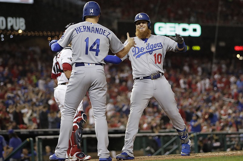 Los Angeles Dodgers third baseman Justin Turner (10) celebrates his three-run home run off Washington Nationals relief pitcher Wander Suero with Enrique Hernandez (14) during the sixth inning in Game 3 of a baseball National League Division Series on Sunday, Oct. 6, 2019, in Washington. (AP Photo/Julio Cortez)