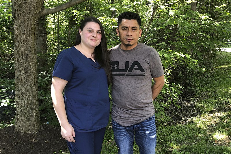 In a photo taken June 21, 2019, Alyse Sanchez and her husband, Elmer Sanchez, pose for The Associated Press in Sandy Spring, Md. The Sanchezes and five other couples have filed a lawsuit in U.S. District Court in Maryland arguing U.S. immigration authorities are luring couples to marriage interviews only to detain the immigrant spouses. (AP Photo/Regina Garcia Cano)