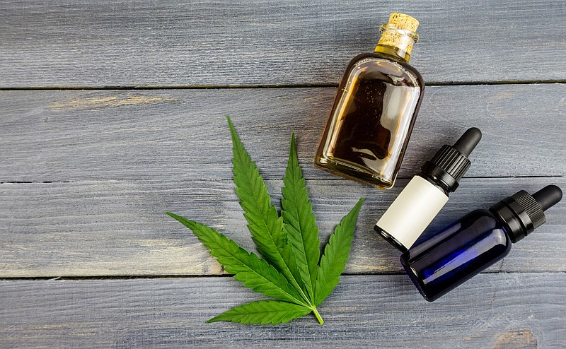 Hemp leaf on wooden table, cannabis oil extracts in bottles cbd tile marijuana hemp / Getty Images
