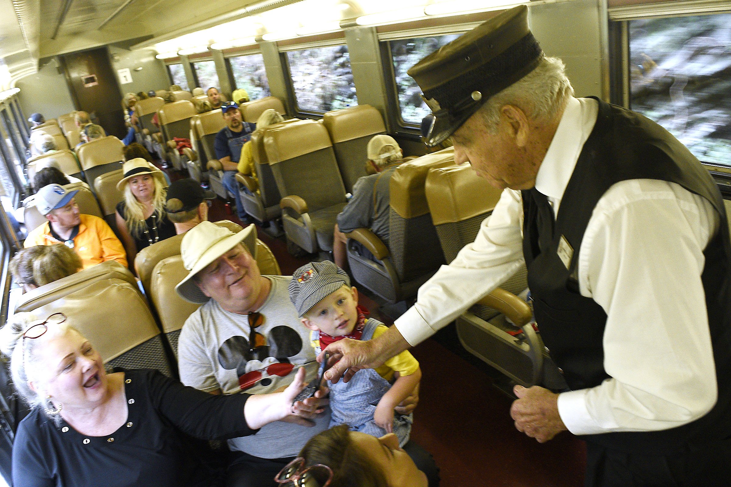 Staff Photo by Robin Rudd/ Conductor Bill Larson interacts with the passengers.