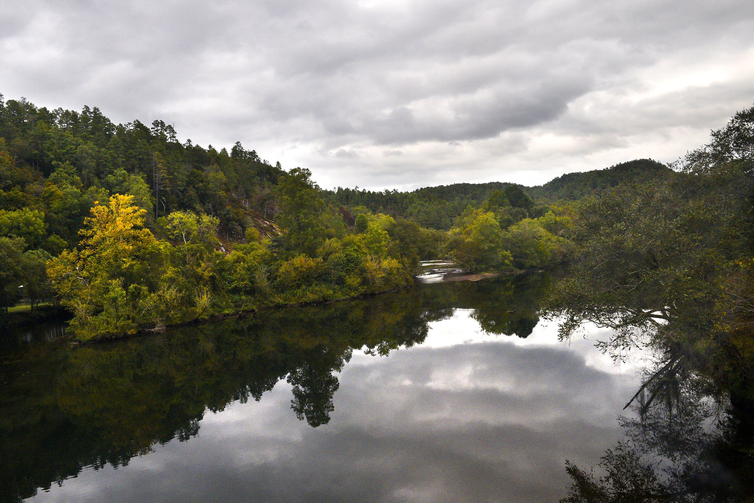 Staff Photo by Robin Rudd/ The Fall colors are somewhat muted as the trains crosses the Hiwassee River on the return trip.