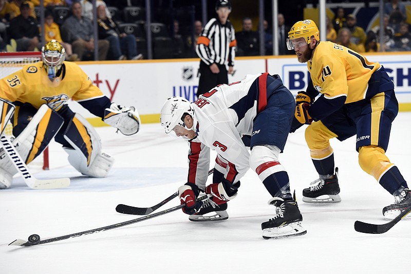 AP photo by Mark Zaleski / Washington Capitals defenseman Nick Jensen (3) reaches for the puck as Nashville Predators defenseman Mattias Ekholm, right, moves in during the first period of Thursday's game in Nashville.