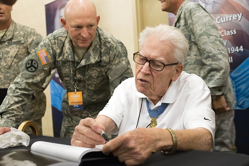 This Sept. 12, 2014 file photo shows Medal of Honor recipient Francis Currey, right, as he takes part in an autograph session at the Congressional Medal of Honor Society convention in Knoxville, Tenn. New York Gov. Andrew Cuomo has directed flags on state government buildings to be flown at half staff, Oct. 11, 2019, in honor of Currey, a Selkirk, N.Y., resident who died Oct. 8, 2019. He was 94. (Photo by Paul Efird/Knoxville News Sentinel via AP)