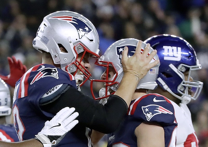 AP photo by Elise Amendola / New England Patriots quarterback Tom Brady, left, celebrates with Gunner Olszewski after scoring a touchdown on a quarterback sneak in the second half of a home game against the New York Giants on Thursday.