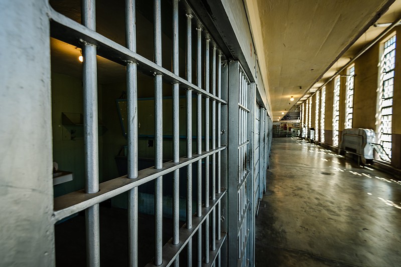 Looking down a prison cell block at bars. Incarceration, jail and prison. / Getty Images/iStockphoto/Photos597