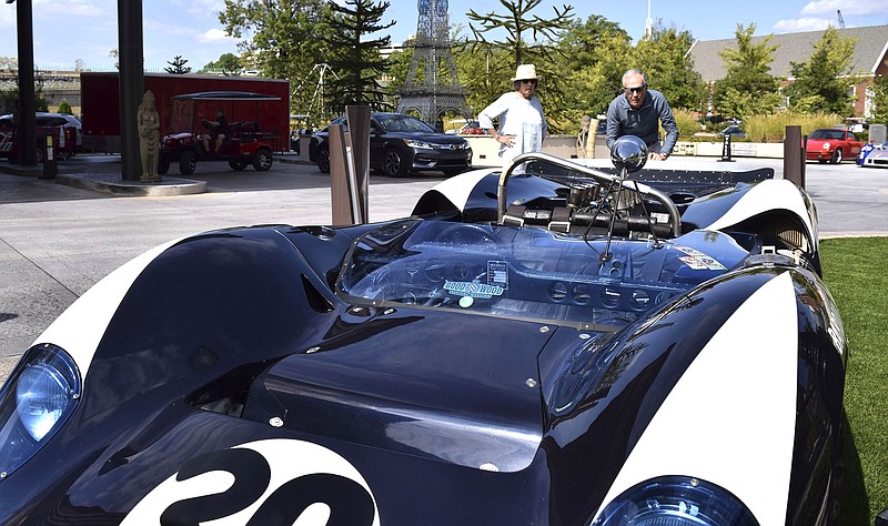 From left, Mardy and Jack Miller, of Chattanooga, look over a Goodwood Lola race car outside the Westin.  The Chattanooga MotorCar Festival is coming together before the official start Friday morning.  Photographs were made on October 10, 2019. / Staff Photo by Robin Rudd  