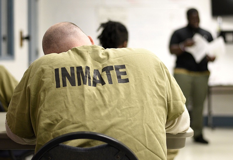 Staff file Photo by Robin Rudd / A Silverdale inmate works on a problem in his notebook in July. He was in a class called Baby U, a program to teach "dad skills" to current and former inmates.