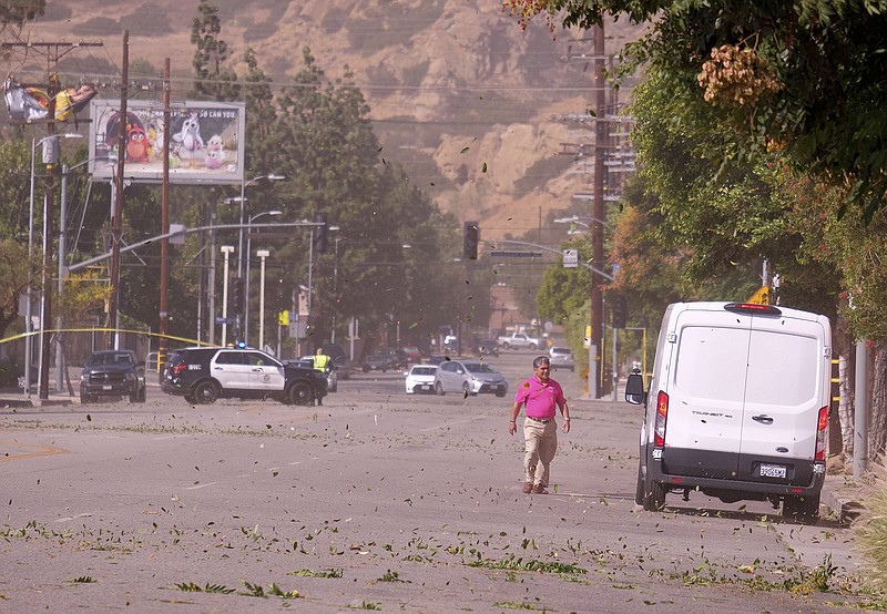 Strong Santa Ana winds in Chatsworth, Calif., blew across power lines causing them to arc and transformers to explode. Power was out for street signs, businesses and residents along Devonshire St. from Topanga Canyon Blvd. to Variel Ave. on Thursday, Oct. 10, 2019. (Dean Musgrove/The Orange County Register via AP)