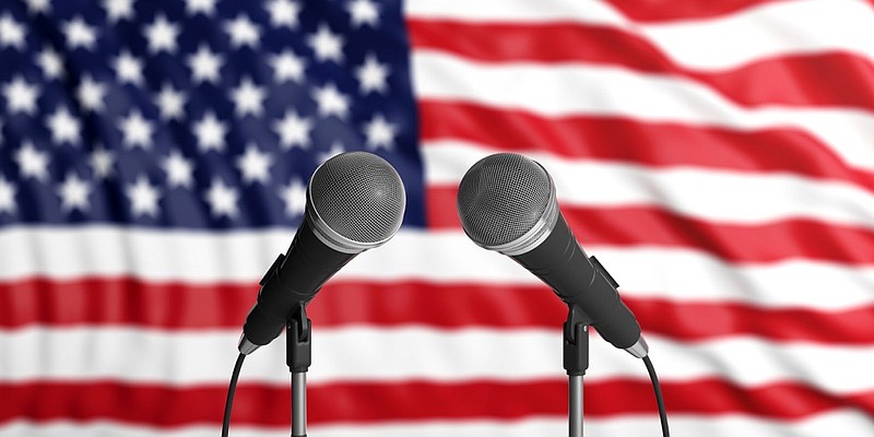 America blur flag backdrop, two cable microphones in front. Political, business concept. 3d illustration presidential debate tile election tile / Getty Images 
