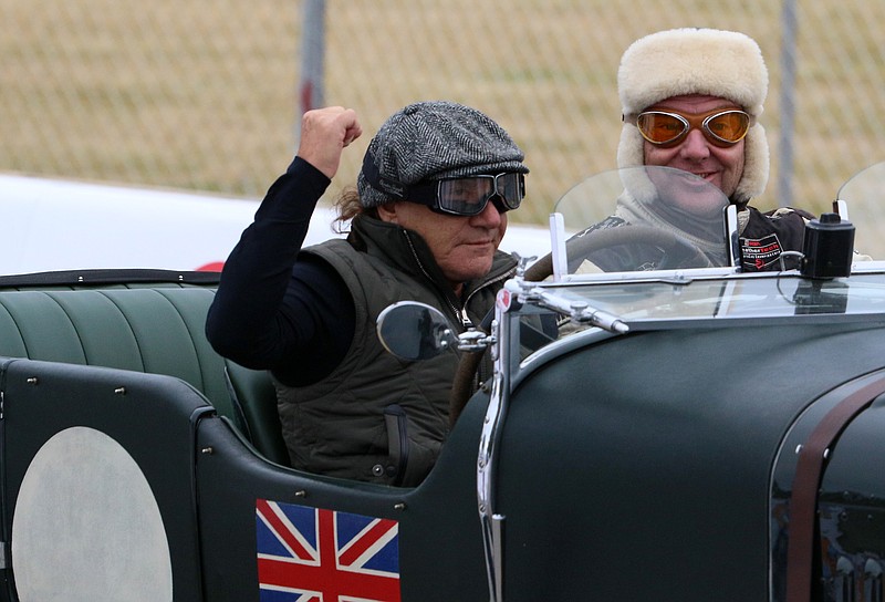 Staff photo by Erin O. Smith / Brian Johnson of AC/DC raises his fist while driving the Bentley Thunderguts during the Chattanooga MotorCar Festival time trials along Riverfront Parkway in Chattanooga, Tennessee. 