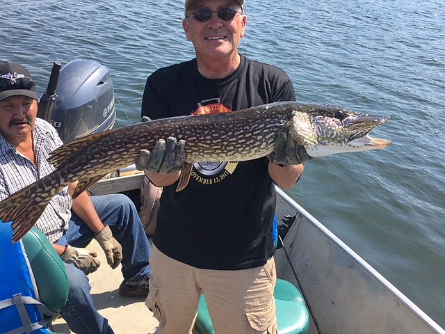 Photos contributed by Roger Smith / The author displays a nice northern pike caught in God's Lake. The Cree guide Fraser, who grew up on God's Lake, takes it all in stride.