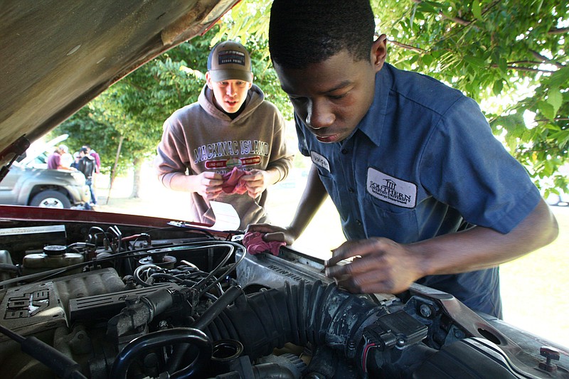 Staff photo by Wyatt Massey / Valden Gardiner, right, looks over the engine of a Ford Explorer on Oct 13 as part of Southern Adventist University's free vehicle inspections at the Samaritan Center.
