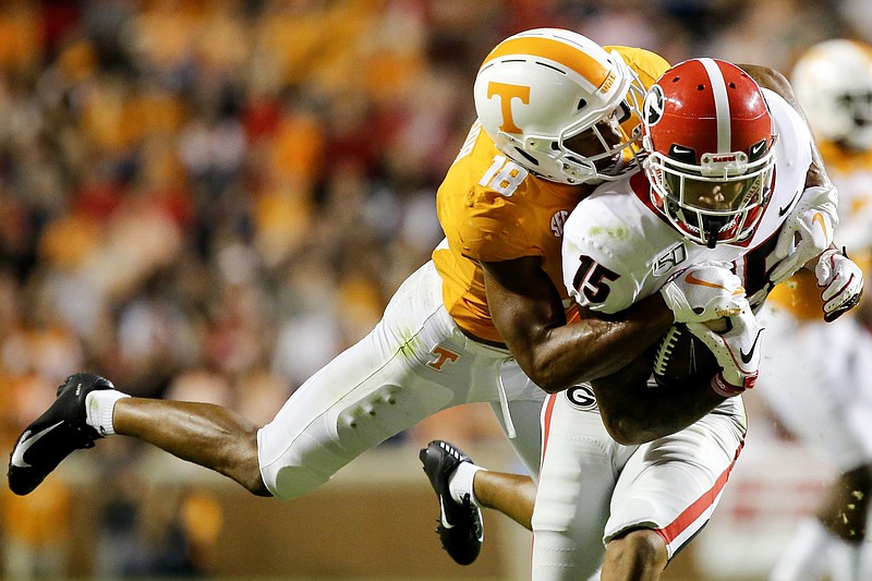 Staff photo by C.B. Schmelter / Tennessee defensive back Nigel Warrior (18) brings down Georgia wide receiver Lawrence Cager (15) at Neyland Stadium on Saturday, Oct. 5, 2019 in Knoxville, Tenn.